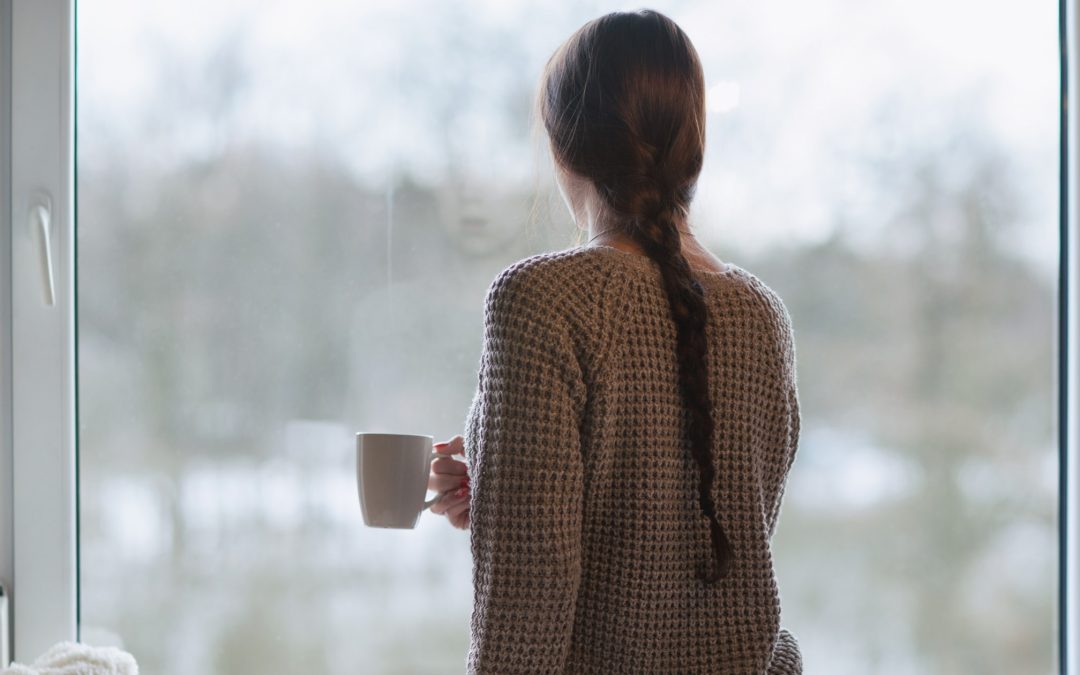 Woman with mug gazing outside