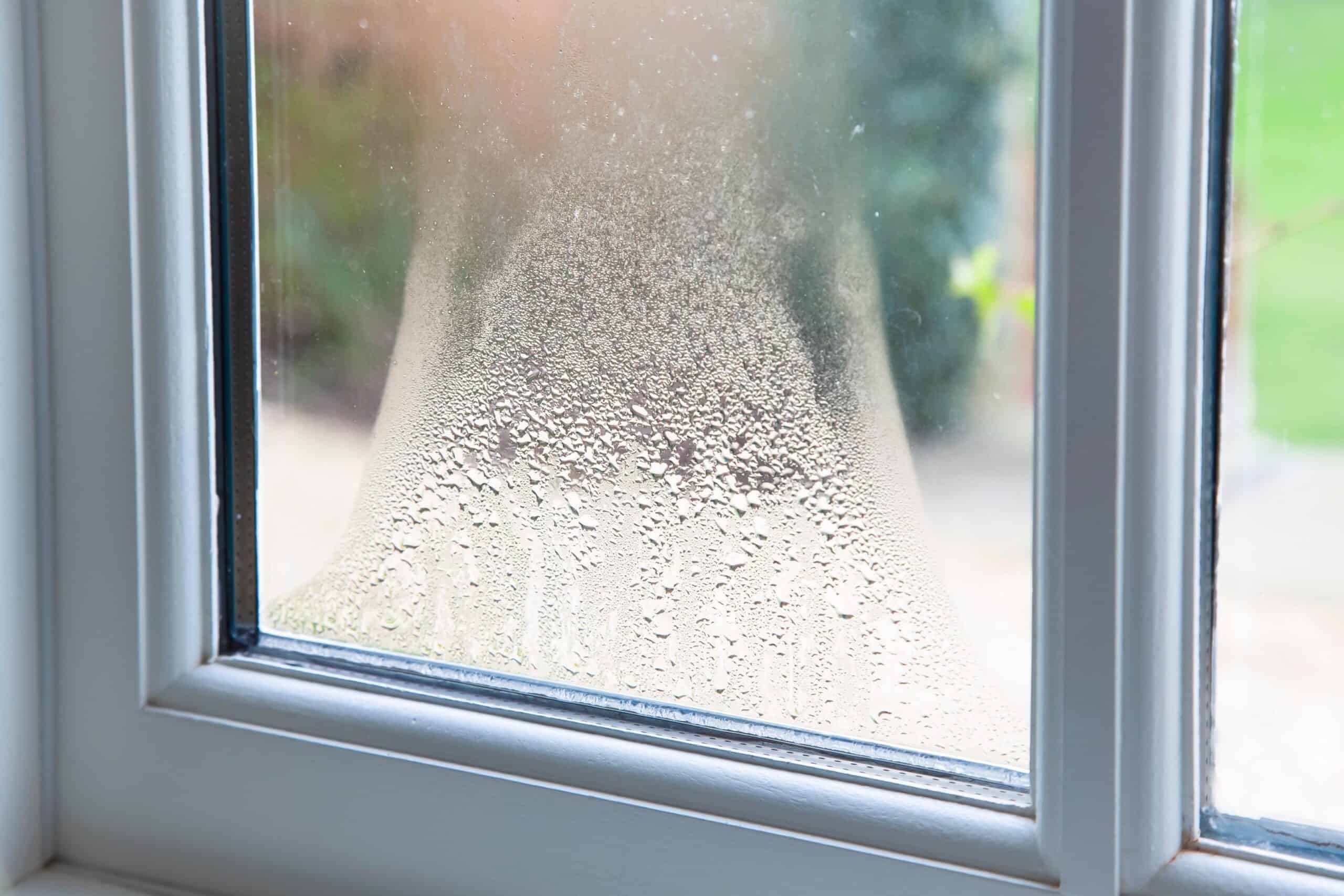 Frosted window with condensation, showcasing double-glazed glass for insulation.